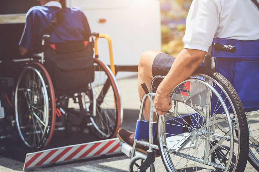 Disabled people sitting in wheelchairs waiting to get on to the public bus